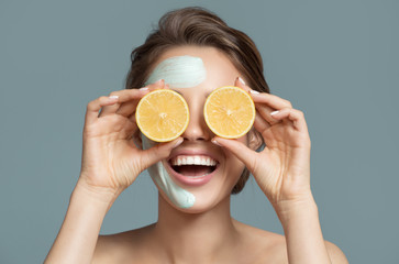 Portrait of beautiful woman with blue cream mask on her face.