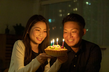 フルーツケーキで誕生日を祝う若いカップル