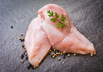 raw chicken breast with herbs and spices on black plate - Raw uncooked chicken meat marinated with ingredients for cooking
