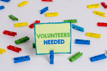 Conceptual hand writing showing Volunteers Needed. Concept meaning need work or help for organization without being paid Colored clothespin papers empty reminder white floor office