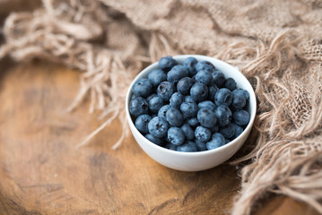 Fototapeta na wymiar Fresh ripe blueberries in a bowl, vintage look 
