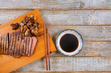 Grilled beef steak medium rare on wooden cutting board.