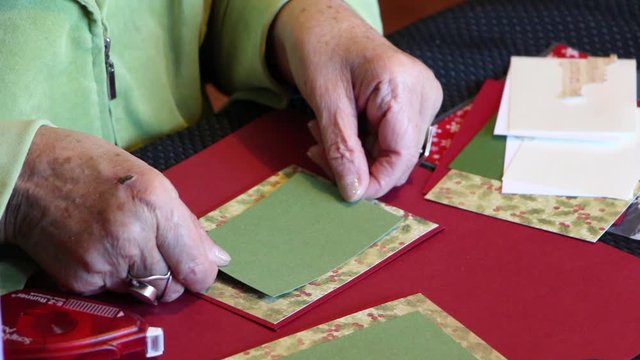 Old lady crafts ornamental cards (Close Up)