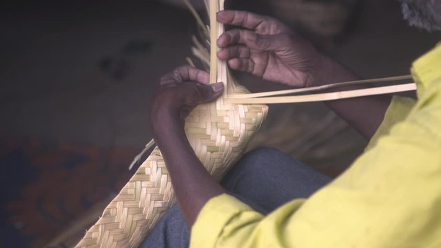 Tribal man creating bamboo art for living in central India