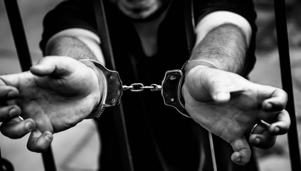 Man with her hands handcuffed in criminal.  Arrest, gangster, pain concept.