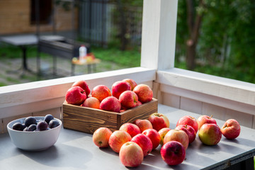    Apples are in a wooden container on the table.Horizontally.