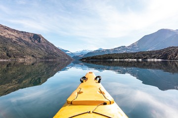 Point of view shot of a yellow kayak boat sailing in beautiful Lake Wanaka, New Zealand
