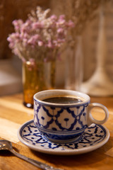 Coffee in beauty ceramic cup on wood table background.