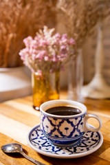 Coffee in beauty ceramic cup on wood table background.
