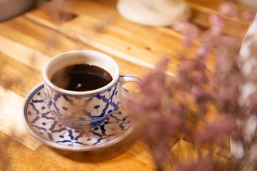 Coffee in beauty ceramic cup on wood table background.