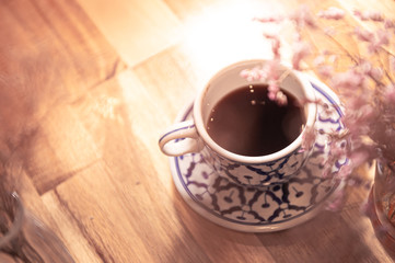 Coffee in beauty ceramic cup on wood table background.