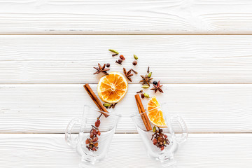 New Year beverage. Ingredients for mulled wine in glasses on white wooden background top view space...