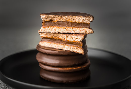 Alfajor with dulce de leche sweet pastry cake, a traditional Argentine dessert with chocolate and caramel