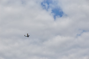 Small airplane flying in the sky with clouds