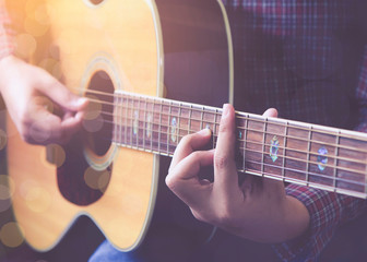 close up of man hands playing guitar