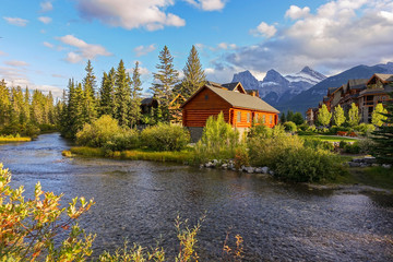 Spring Creek Alpine Village Landscape with Distant Three Sisters Mountain in Town of Canmore, Alberta Foothills of Canadian Rockies - obrazy, fototapety, plakaty