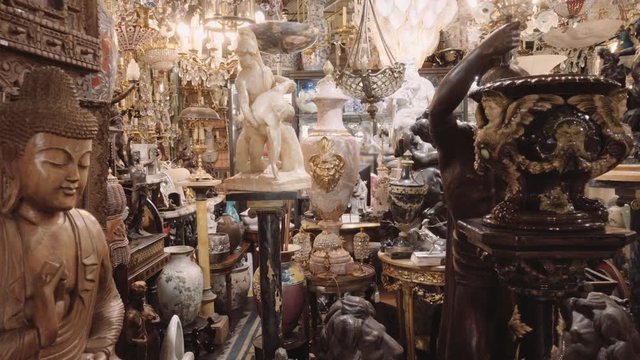 Antique shop in a flea market, lamps, vessels and statues. 4k