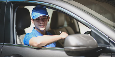 Young delivery man preparing the products to customer while sitting on the car