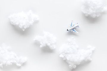Fly by plane concept. Airplane model and clouds on white background top view
