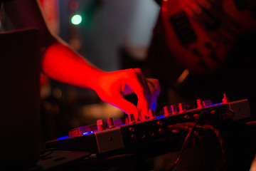 Dj mixes the track in the nightclub at a party