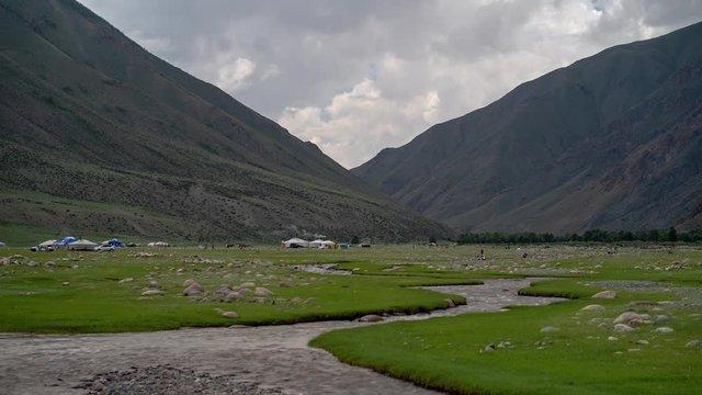 Mongolian countryside cloud time lapse with river, mountains, yurts/gers in the ​background, Uvs Province
