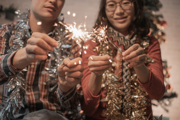 Couple people are celebrating christmas and holidays happily near beautifully decorated christmas tree, christmas concept