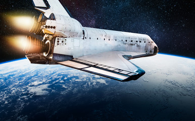 Space shuttle in dark outer space near Earth. Rocket on orbit of the planet. Elements of this image furnished by NASA