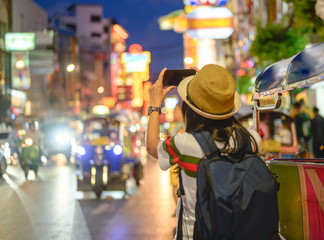 hand of woman tourist taking of shot photo in Chinatown of Bangkok, Yaowarat famous and popular place with street food for tourist