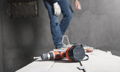 Cordless screwdriver on wooden table. Construction tool