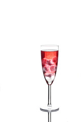 Glass of red champagne with ice on white background