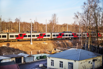 Fototapeta premium electric train leaves the autumn forest in the morning