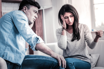 Tired upset woman looking on the thermometer with her boyfriend