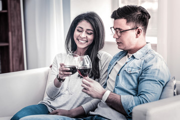 Pleasant couple spending time together with glasses of wine