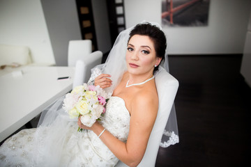 Portrait of beautiful happy bride sitting on sofa