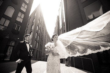 Bride and groom walking in the city, wedding day, marriage concept. Bride and groom in urban...