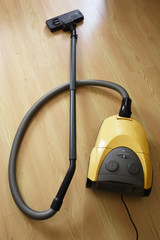 Old vacuum cleaner on parquet floor