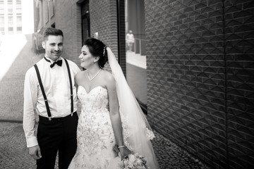 Bride and groom walking in the city, wedding day, marriage concept. Bride and groom in urban...