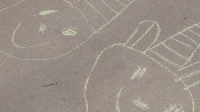Slow motion. Little girl is playing hopscotch on sunny Spring day suburbs.