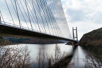 Modern suspension bridge across reservoir Los Barrios de Luna