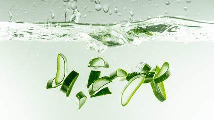 Aloe vera pouring to water on white background