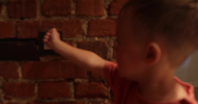 Little boy pressure the light switch and turns off the light in the room. Saving energy. Energy efficiency