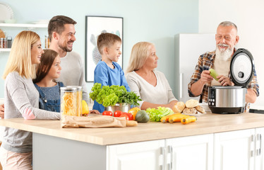 Happy family using modern multi cooker in kitchen