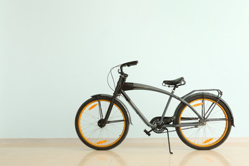 Modern bicycle near light color wall