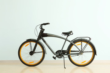 Fototapeta na wymiar Modern bicycle near light color wall