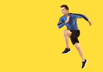 Fototapeta na wymiar Running sporty man on color background
