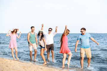 Fototapeta premium Happy friends on sea beach at resort