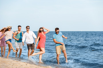 Obraz premium Happy friends on sea beach at resort
