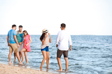 Happy friends on sea beach at resort