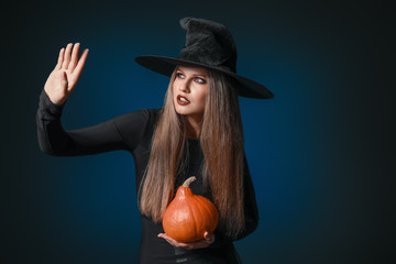 Beautiful woman dressed as witch for Halloween on dark background