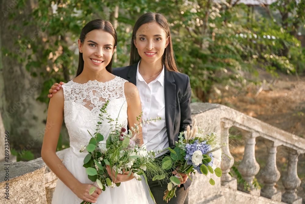 Wall mural Beautiful lesbian couple on their wedding day outdoors